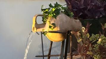 A water feature with a spout and a plant growing out of it.