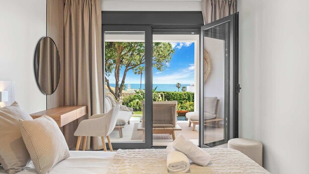 A hotel room with a bed, seating area, and a view of the sea. - Stunning villa Dolce vita - ref 69 (Las Lagunas de Mijas)