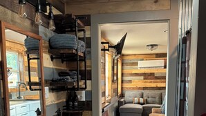 A compact, modern bathroom with a sink, mirror, towel rack, and toilet. - Cozy 1-bedroom cabin in Protection with cool AC (Protection)