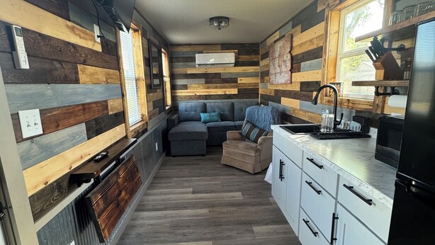 A compact kitchen with a built-in stove, a sink, and a refrigerator. - Cozy 1-bedroom cabin in Protection with cool AC (Protection)