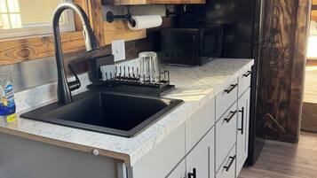 Fridge, microwave, coffee/tea maker, cookware/dishes/utensils
