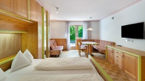 A room with a bed, a sofa, a dining table, and a TV. - Apartment '8 Residence Ciasa Ulli Typ B' with Mountain View, Shared Terrace and Wi-Fi (San Cassiano)
