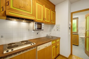 Une cuisine avec des meubles en bois, un four à micro-ondes, une cuisinière et un lave-vaisselle.