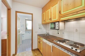 A kitchen with wooden cabinets, a stainless steel stove, and a microwave.