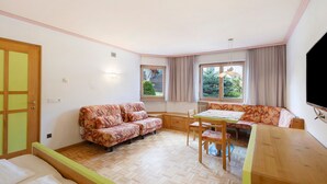 Une pièce comprenant un canapé, une table à manger et un téléviseur.