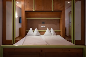 Ein Doppelbett mit Holzkopfseitenverkleidung, ein Nachttisch und eine Wandlampe.