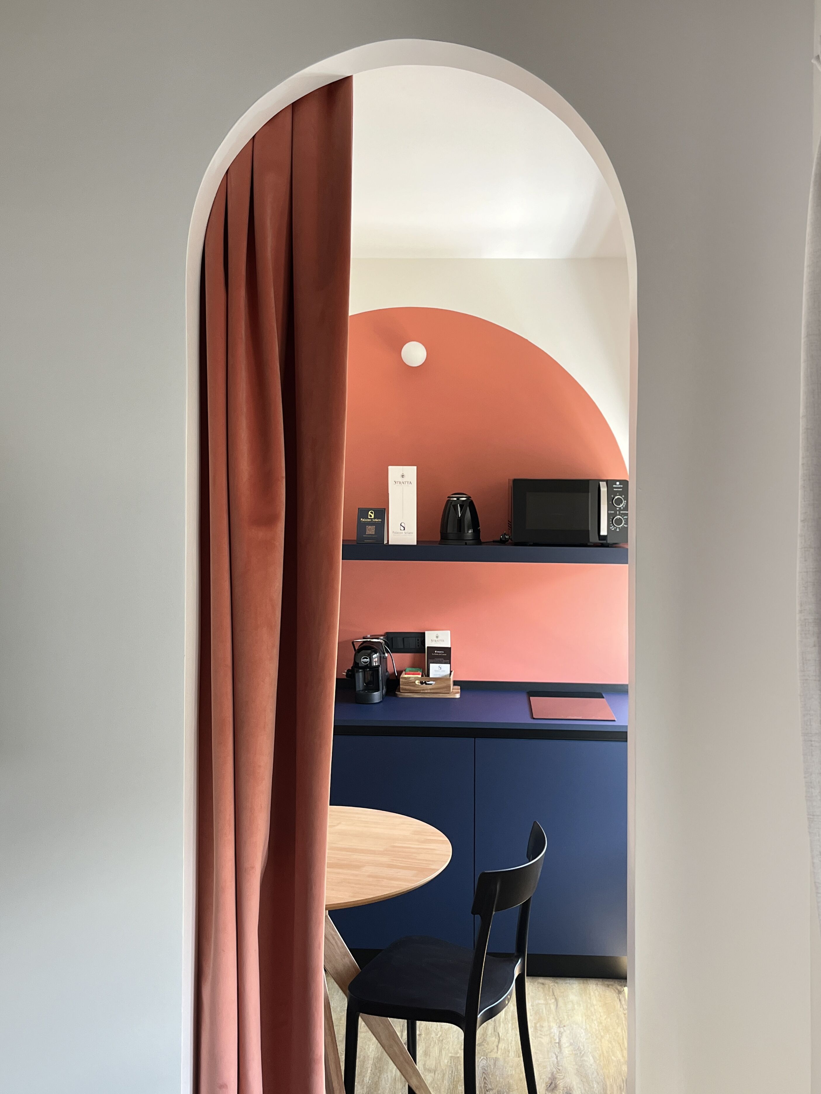 Une cuisine moderne équipée d’un four à micro-ondes, d’une machine à café et d’une petite table avec une chaise.