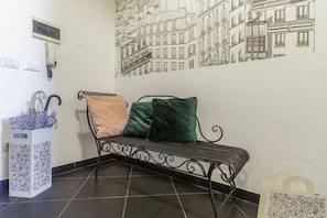 A bench with two pillows, a wall-mounted phone, and a tiled floor. - This colorful and welcoming apartment, ideal for up to 4 people, is strategically located in Lecce: outside the restricted traffic zone but just steps from the historic center. Just 400 meters from Porta San Biagio, it's easy to immerse yourself in the w (Lecce)