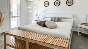 Ein modernes Schlafzimmer mit Bett, Nachttisch, Lampe und Wandbildern.