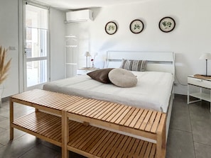 A modern bedroom with a bed, bedside table, lamp, and wall art. - Al CasAle - Villa in Porto Rotondo (Olbia)