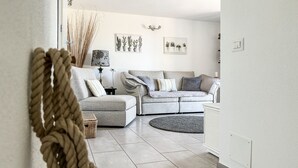 Ein Wohnzimmer mit einer Couch, einem runden Teppich und Wandgefäßen.