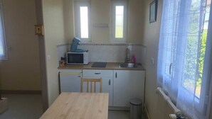 A small kitchen with a microwave, sink, and window.