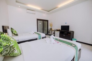 A hotel room with two beds, a TV, a desk, and a mirror.