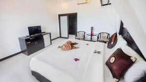 A hotel room with a bed, a TV, a desk, and a chair.