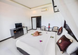 A hotel room with a bed, a TV, a desk, and a chair.