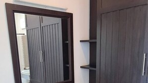 A bathroom with a dark wooden vanity, a mirror, and a cabinet.