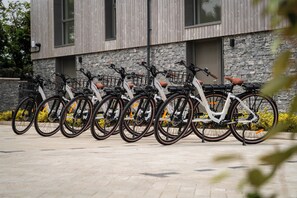 A row of bicycles parked in front of a building with a stone facade and large windows. - Hidden 19- Coastal Hot Tub (St Ives)