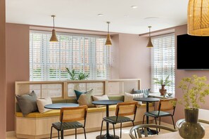 A cozy seating area with a sofa and chairs, a small table, and a TV mounted on the wall. - Hidden 19- Coastal Hot Tub (St Ives)