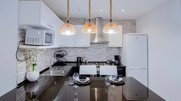 Appartement Deluxe, balcon, vue plage | Cuisine privée | Grand réfrigérateur, micro-ondes, four, plaque de cuisson