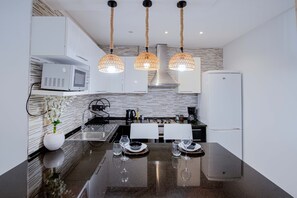 Appartement Deluxe, balcon, vue plage | Cuisine privée | Grand réfrigérateur, micro-ondes, four, plaque de cuisson