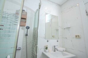 Appartement Deluxe, balcon, vue plage | Salle de bain | Douche, articles de toilette gratuits, sèche-cheveux