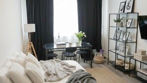 A modern living room with a sofa, a coffee table, a desk, and a TV. - Sunny Stay in Alexanderplatz (Berlin)