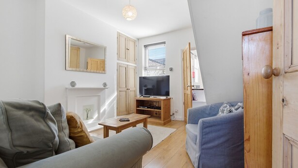 Ein Wohnzimmer mit einer Couch, einem Couchtisch, einem Fernseher und einem Kamin.