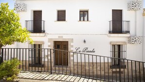 A white building with balconies, a wooden door, and the name 'La Losada' on the facade.