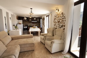 A spacious living area with a dining table, sofas, and a kitchen in the background. - LA POSADA DE LA MUELA (Algodonales)