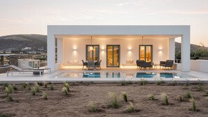 A modern house with a pool, outdoor seating, and a view of the landscape. - Alkinoe Villa Paros, Bill & John Paros (Paros)