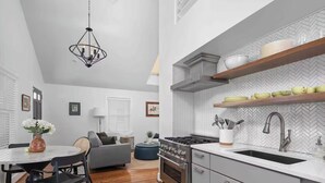 Eine moderne Küche mit einem Gasherd, Edelstahlgeräten und einer Backsplash mit Fischgrätmuster.