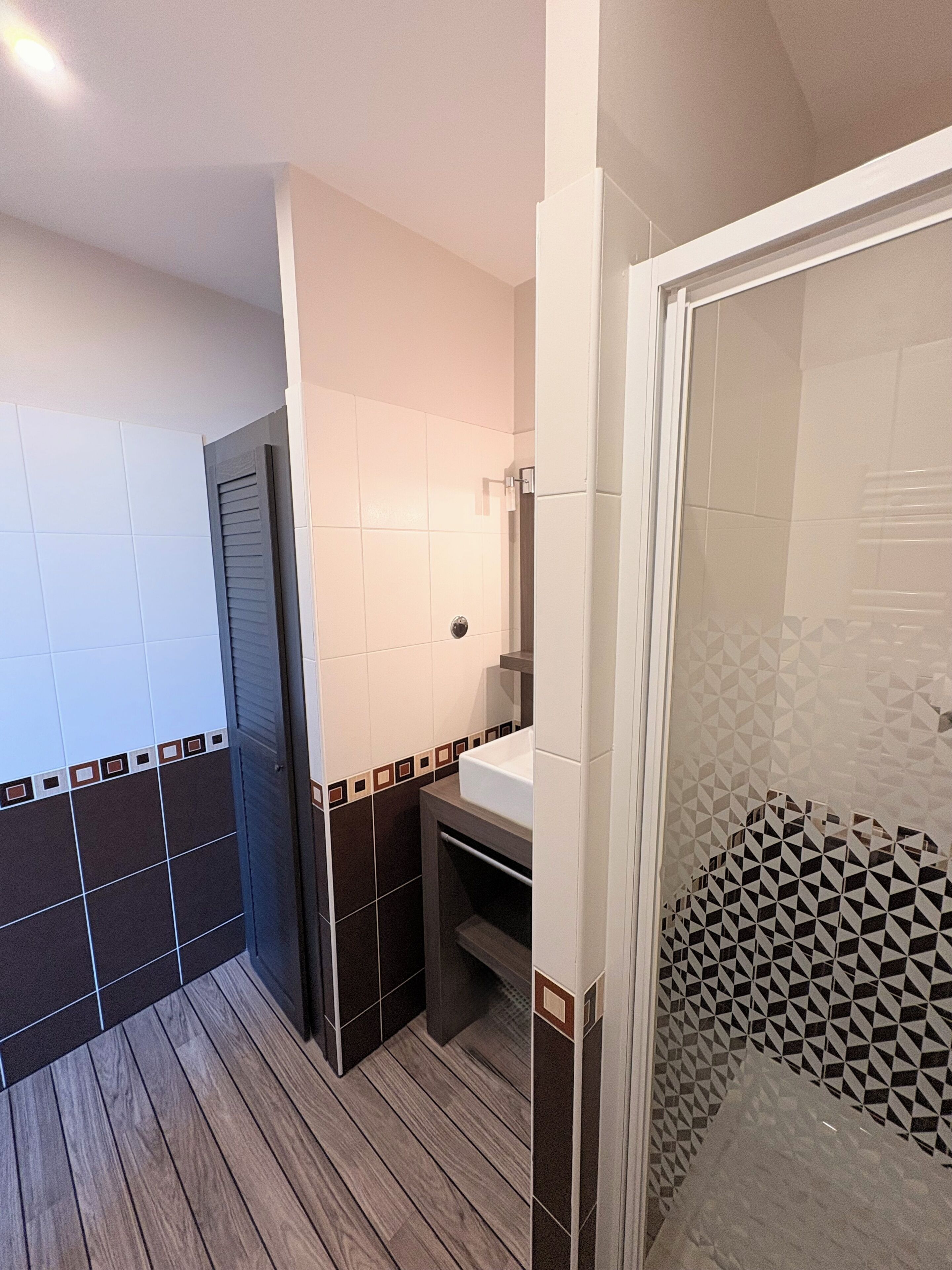 Un baño con ducha, lavabo y espejo.