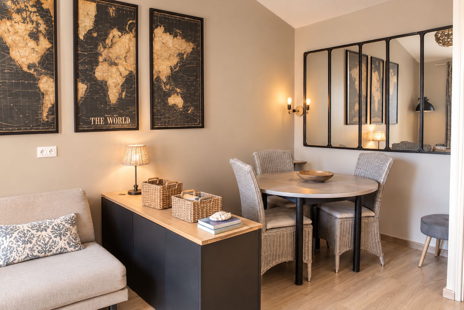 Una sala de estar moderna con un sofá, una mesa de comedor con sillas de mimbre, una mesa de centro redonda y un espejo montado en la pared.