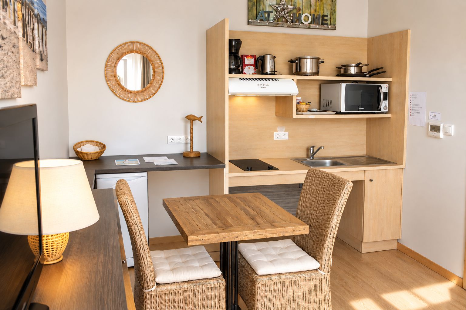 A compact kitchen with a dining area, equipped with a microwave, stove, and a sink.