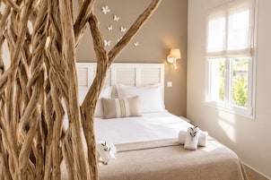 Un dormitorio con cama, mesita de noche, lámpara y ventana.