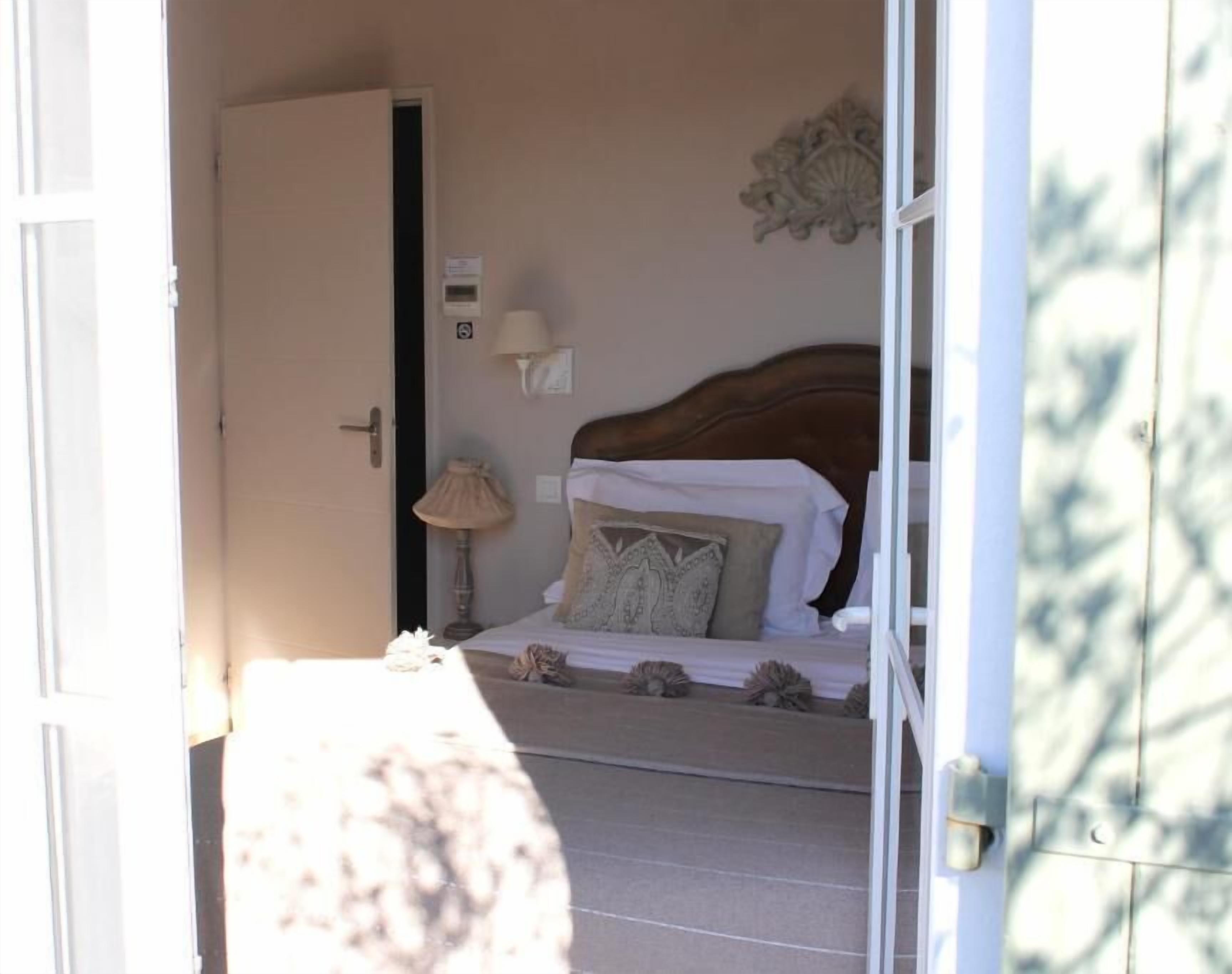Une chambre à coucher avec un lit, une table de chevet, une lampe et un élément décoratif mural.