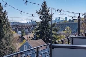 Blick auf eine Brücke, Bäume und ein Gebäude mit einer Metallbedachung.