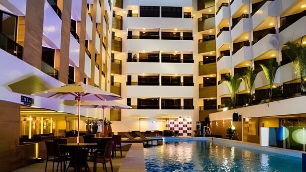 A multi-story hotel with a swimming pool, outdoor seating, and a bar area. - Gold Flat - Bela Vista (João Pessoa)
