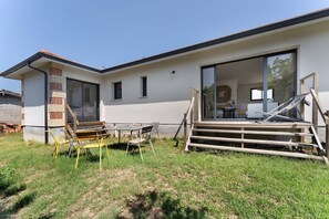 Une maison moderne dotée d’une grande porte-fenêtre coulissante qui donne sur un patio.