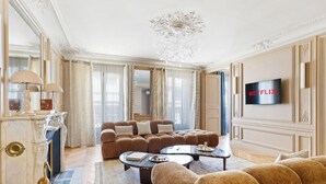 Una sala de estar lujosa con un conjunto de sofá, una mesa de centro, una chimenea y un televisor montado en la pared.