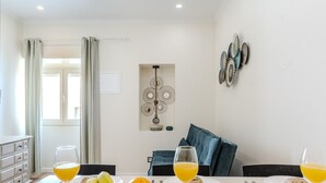 Een ontbijtruimte met een tafel gedekt, inclusief fruit, gebak en glazen sinaasappelsap.