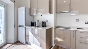 A modern kitchen with white appliances, beige cabinets, and a built-in microwave. - #379 Sunny Corner | Albufeira Stay (Albufeira)