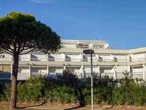 A multi-story building with balconies and a tree in the foreground. - La Frégate by Interhome (Port Camargue)