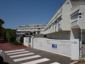 A multi-story residential building with balconies, a gated entrance, and a pedestrian crossing. - La Frégate by Interhome (Port Camargue)