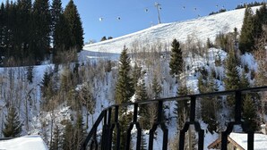 A snow-covered mountain with a ski lift and a building with a snow-covered roof. - Bernkogel by Interhome (Saalbach-Hinterglemm)