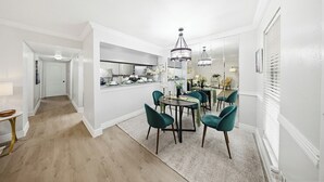A modern dining area with a chandelier, a kitchen in the background, and a hallway leading to another room. - Newly furnished  • 3mins to Galleria  •Uptown Houston •King & Queen (Houston)