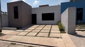 A modern building with a flat roof, large windows, and a paved courtyard. - Casa Confort Ahuachapan/ 3 suites with AC & Smart Tvs (Ahuachapan centro)