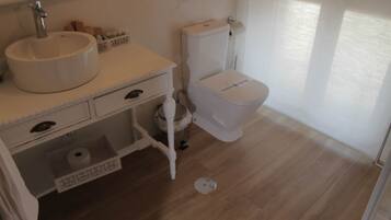 Een badkamer met een wit wastafel, toilet en een spiegel boven de wastafel.