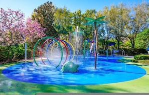Ein Wasserspielplatz mit bunten Ringen und einer zentralen Wasserspüle.