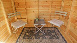 A small wooden room with two white chairs, a small table, and a rug. - Lavender Cottage (Gillingham)